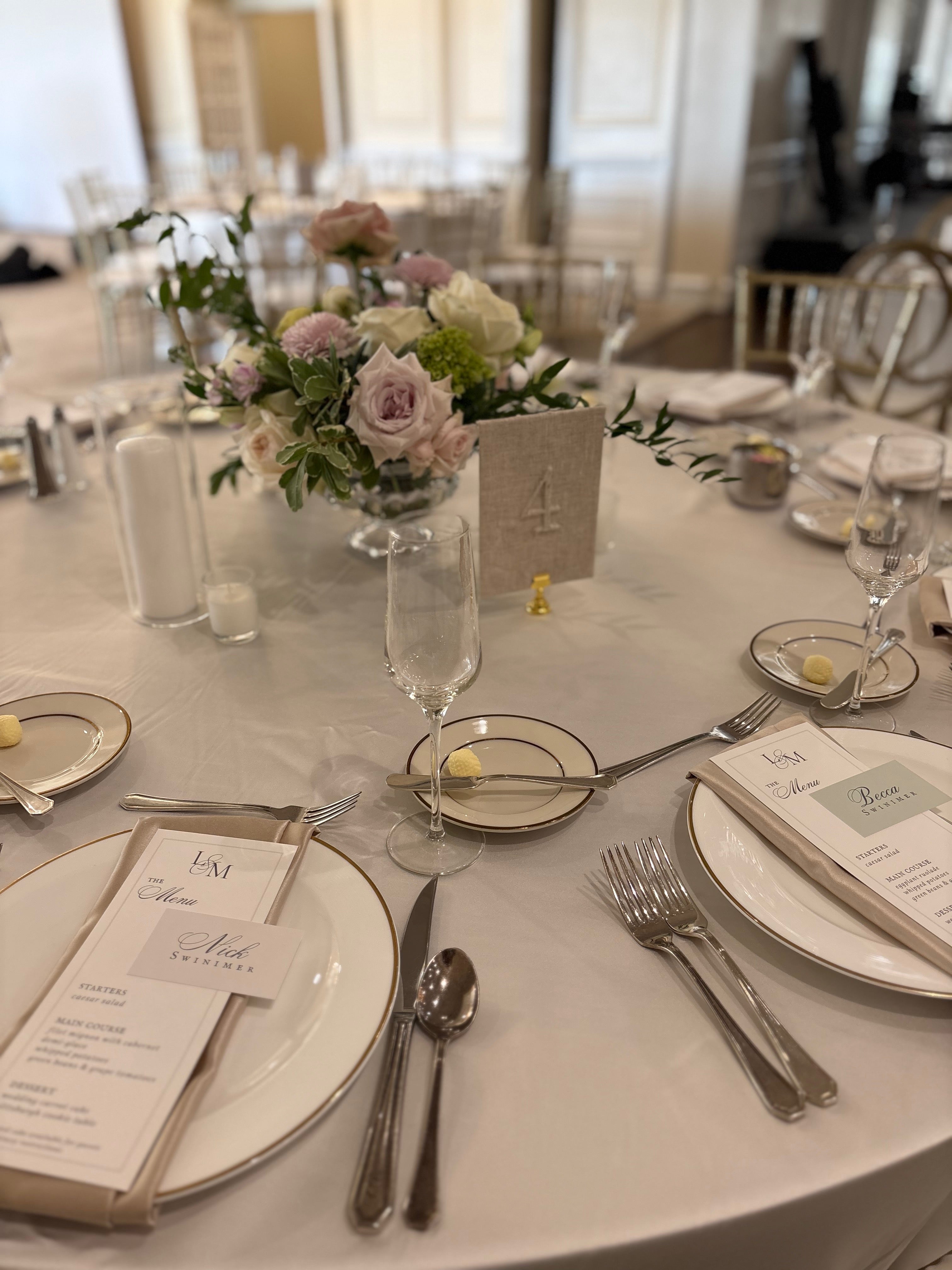 Elegant table setting with floral centerpiece, plates, and silverware in a formal dining room.
