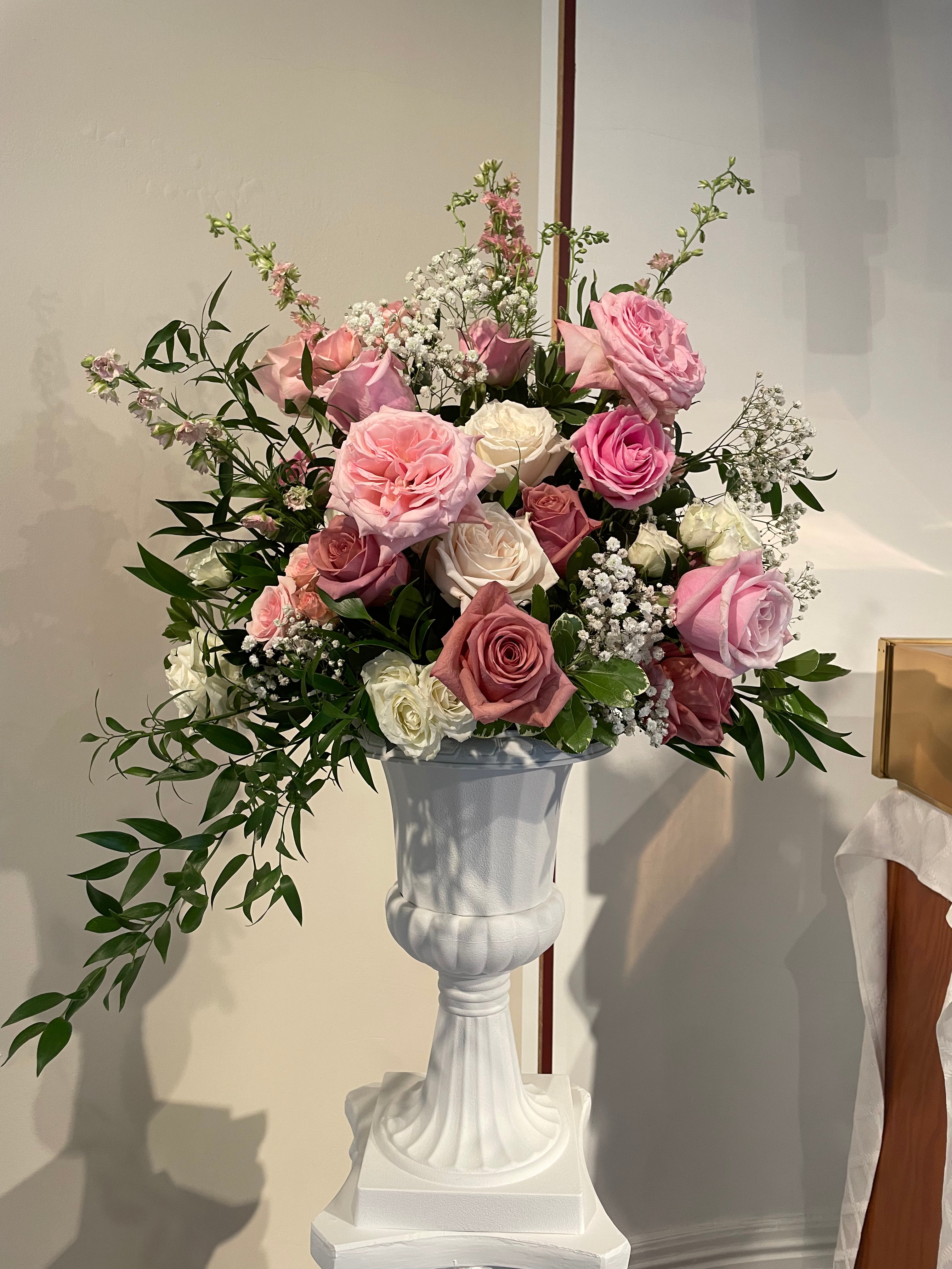 Floral arrangement in a white urn against a neutral background in a Pittsburgh church alter arrangement